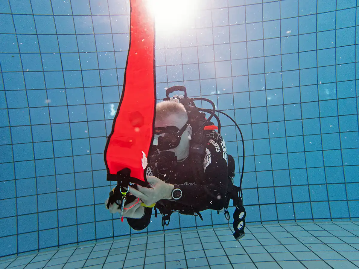 DSMB training - duiker blaast lucht in een boei