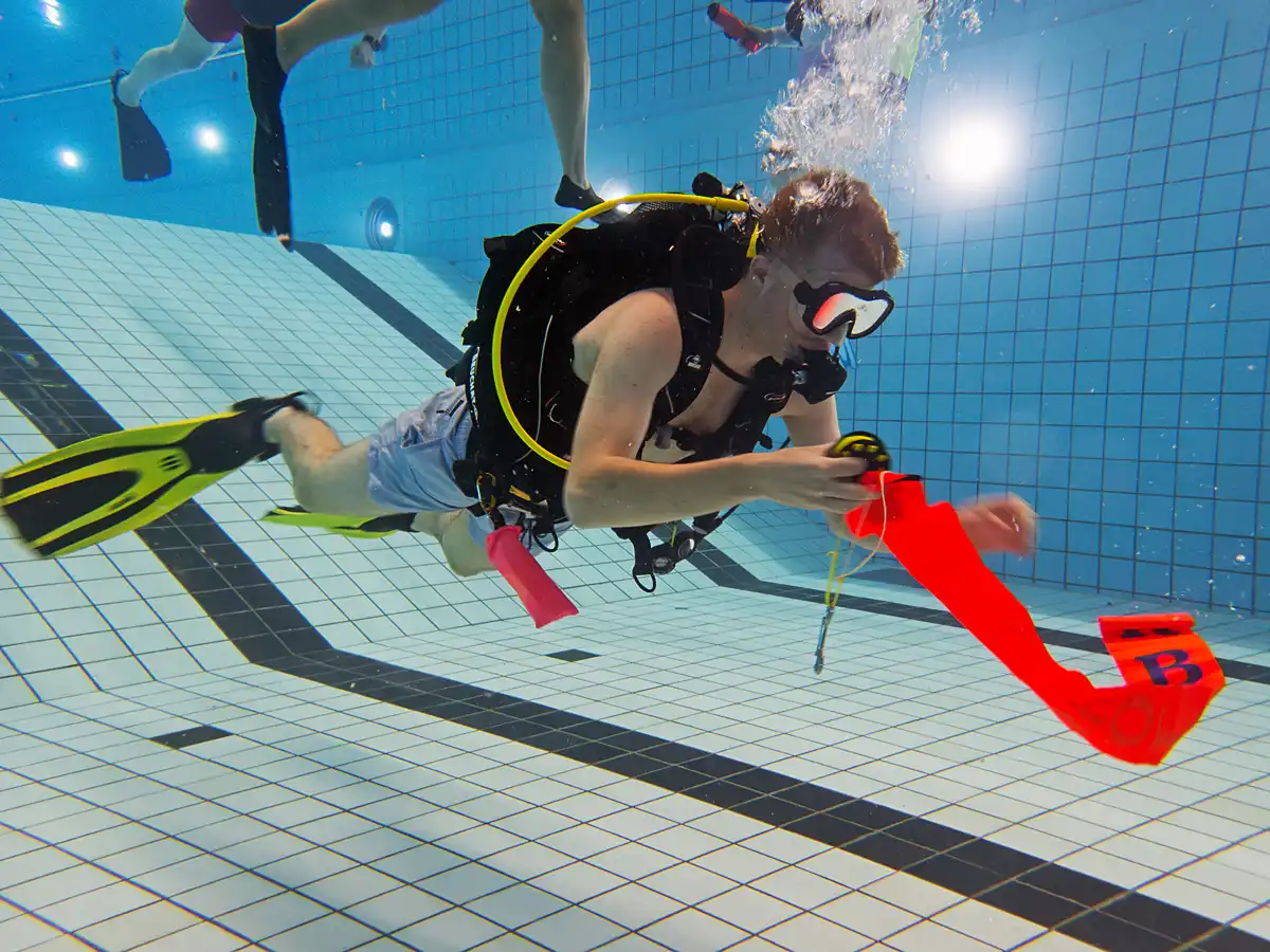SMB training - Een duiker rolt een SMB uit onder water